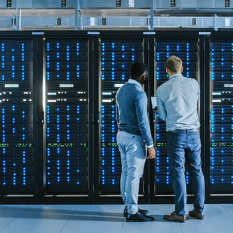 An image of two people working in a data center.